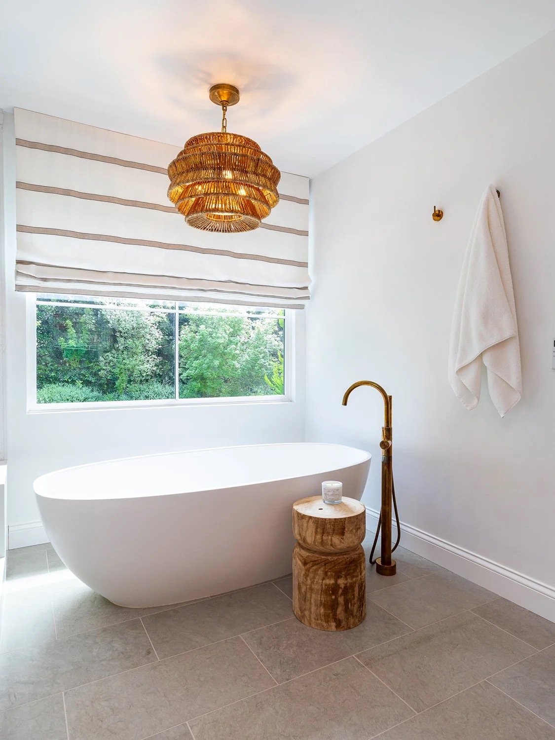 Saddle House primary bathroom by KADI Design with freestanding tub and warm stone detailing